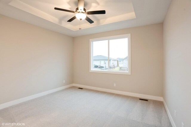 3424 5th Ave SE, Altoona, IA 50009 - unfurnished room with a raised ceiling, light colored carpet, ceiling fan, and baseboards