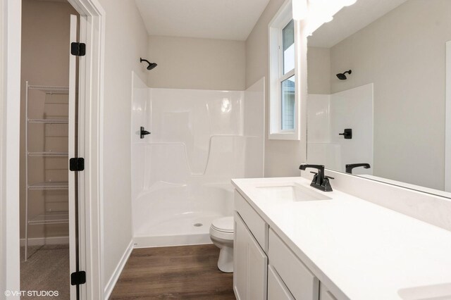 3424 5th Ave SE, Altoona, IA 50009 - full bathroom with a shower, toilet, wood finished floors, vanity, and a spacious closet