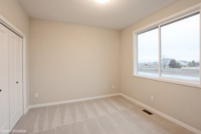 3424 5th Ave SE, Altoona, IA 50009 - unfurnished bedroom featuring light colored carpet, a closet, and baseboards