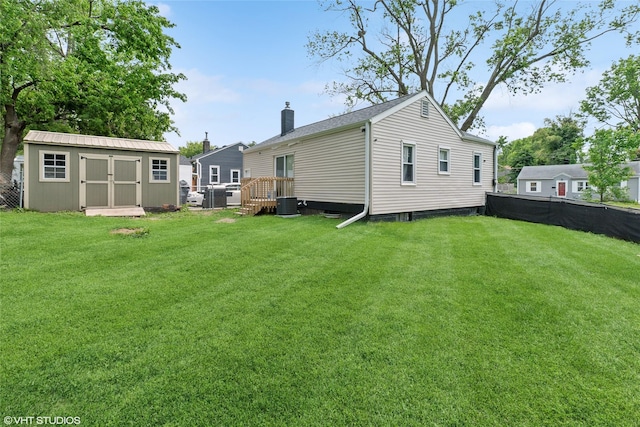 5713 Clark Blvd, Des Moines, IA 50311 - rear view of house with a chimney, a lawn, and central AC unit