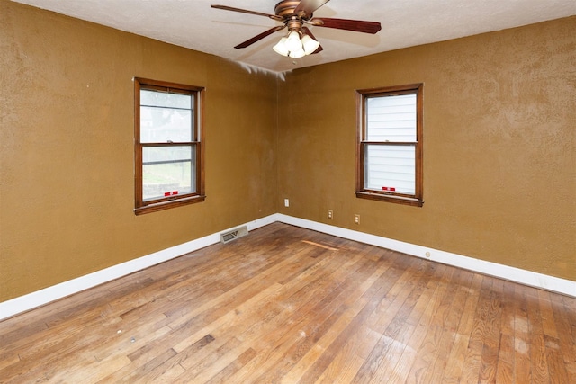 2721 Cornell St, Des Moines, IA 50313 - empty room featuring hardwood / wood-style flooring, baseboards, a ceiling fan, and a textured wall