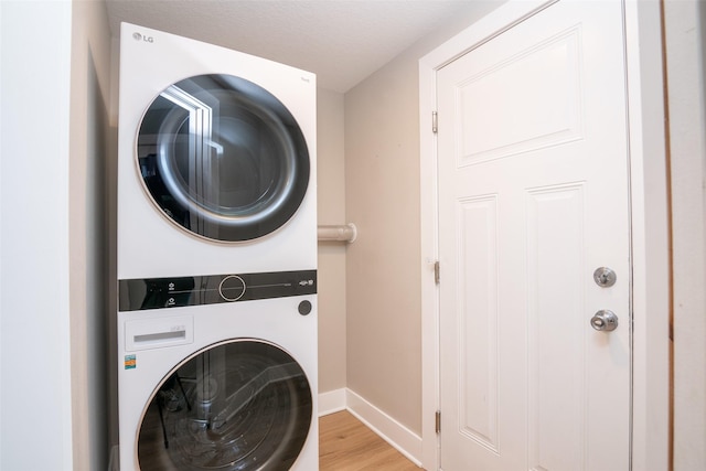 2011 Ammann Dr, Adel, IA 50003 - laundry room featuring stacked washer / dryer, baseboards, and light wood-type flooring