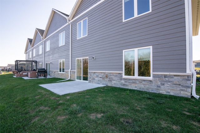 2011 Ammann Dr, Adel, IA 50003 - back of house with an outdoor hangout area, stone siding, and a patio