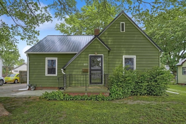 105 N Park Lane Dr, Knoxville, IA 50138 - view of front of house featuring a chimney, a front lawn, and metal roof