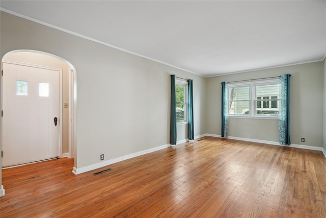 105 N Park Lane Dr, Knoxville, IA 50138 - empty room with arched walkways, light wood-style flooring, crown molding, and baseboards