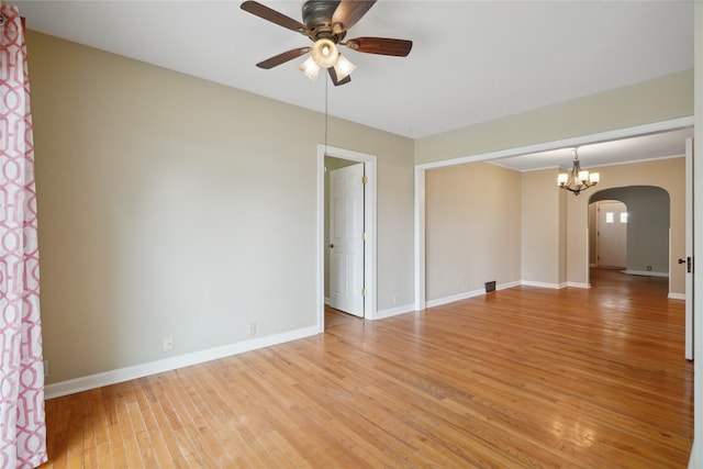 105 N Park Lane Dr, Knoxville, IA 50138 - empty room with arched walkways, a ceiling fan, light wood-type flooring, baseboards, and a chandelier