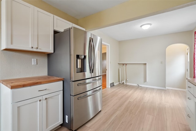 105 N Park Lane Dr, Knoxville, IA 50138 - kitchen featuring stainless steel fridge with ice dispenser, wooden counters, arched walkways, white cabinets, and light wood finished floors