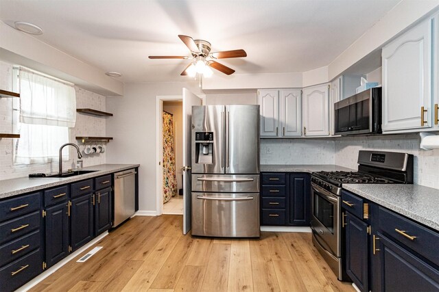 1717 Linn St, Boone, IA 50036 - kitchen with stainless steel appliances, open shelves, ceiling fan, blue cabinetry, and backsplash