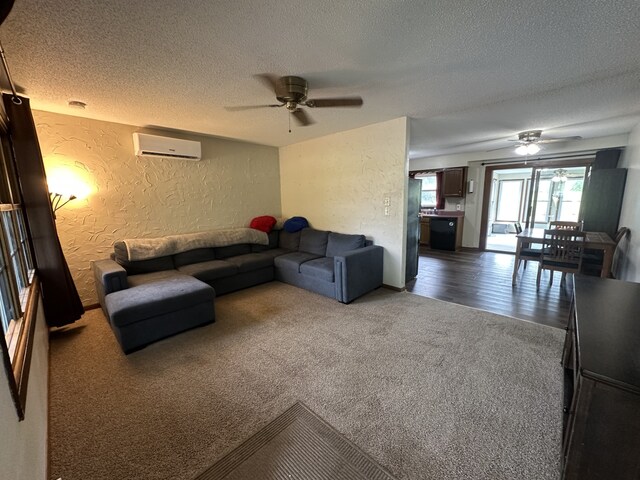 303 S Dewey St, Osceola, IA 50213 - living room with a textured wall, a textured ceiling, a ceiling fan, a wall mounted air conditioner, and carpet floors