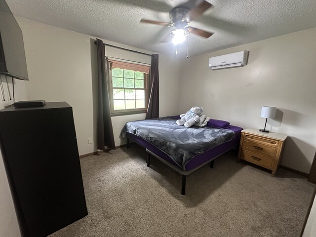 303 S Dewey St, Osceola, IA 50213 - bedroom featuring an AC wall unit, a textured ceiling, light colored carpet, a ceiling fan, and baseboards