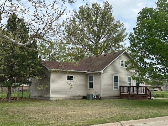 1010 N 17th St, Chariton, IA 50049 - back of property featuring a deck, a lawn, and central AC