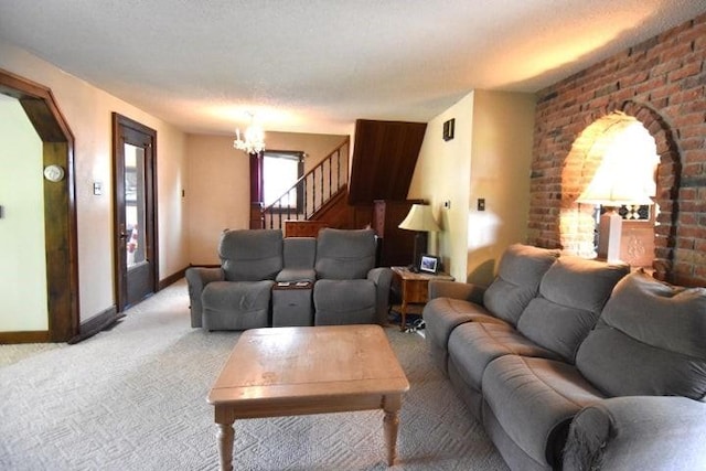 231 S 1st St, Ogden, IA 50212 - living area with light colored carpet, a chandelier, arched walkways, baseboards, and stairs