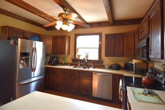 231 S 1st St, Ogden, IA 50212 - kitchen featuring appliances with stainless steel finishes, beamed ceiling, light countertops, a sink, and a ceiling fan