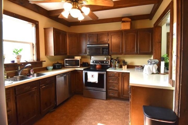 231 S 1st St, Ogden, IA 50212 - kitchen with stainless steel appliances, a sink, a ceiling fan, and light countertops