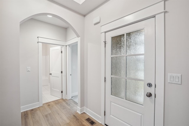 17829 Valley View Dr, Clive, IA 50325 - foyer entrance with arched walkways, light wood finished floors, and baseboards