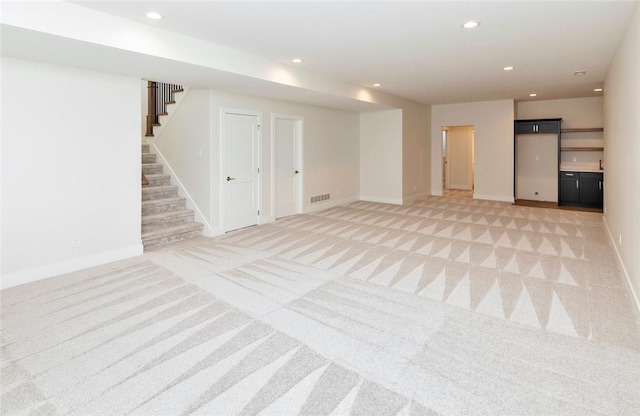 733 17th Ave SE, Altoona, IA 50009 - below grade area with light carpet, stairs, and recessed lighting
