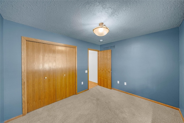810 NE 5th St, Ankeny, IA 50021 - unfurnished bedroom with a closet, carpet floors, baseboards, and a textured ceiling