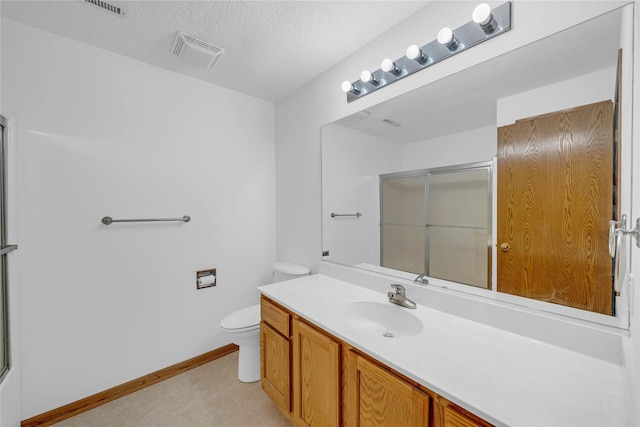 810 NE 5th St, Ankeny, IA 50021 - bathroom featuring vanity, toilet, an enclosed shower, baseboards, and a textured ceiling