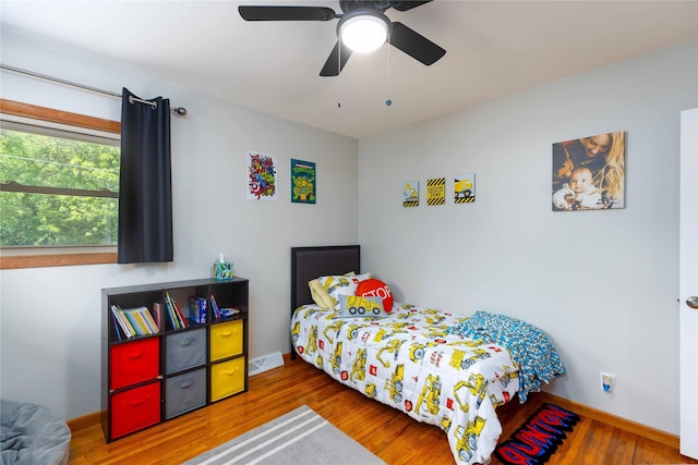 403 S Elm St, Lamoni, IA 50140 - bedroom with wood finished floors, baseboards, and a ceiling fan