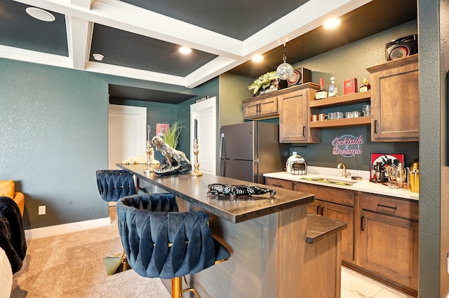 1108 NE Forest Ridge Ct, Ankeny, IA 50021 - kitchen featuring freestanding refrigerator, a breakfast bar area, a sink, coffered ceiling, and a kitchen island