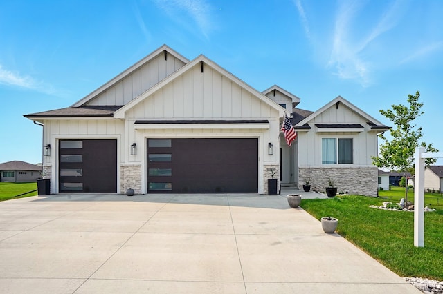 1108 NE Forest Ridge Ct, Ankeny, IA 50021 - view of front of home featuring board and batten siding, a garage, stone siding, a front yard, and driveway