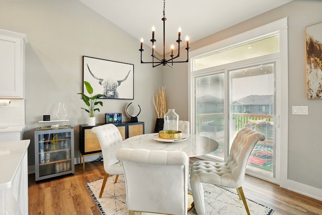 1108 NE Forest Ridge Ct, Ankeny, IA 50021 - dining area with wine cooler, a chandelier, light wood-style floors, and vaulted ceiling