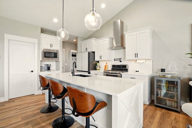 1108 NE Forest Ridge Ct, Ankeny, IA 50021 - kitchen with appliances with stainless steel finishes, wall chimney range hood, wine cooler, backsplash, and vaulted ceiling