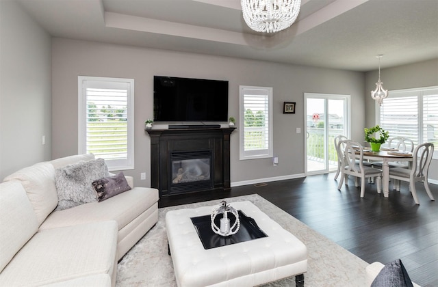 1245 Blue Bonnet Dr, Carlisle, IA 50047 - living room featuring a chandelier, dark wood finished floors, a glass covered fireplace, and baseboards