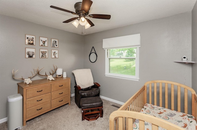 706 S Buxton St, Indianola, IA 50125 - bedroom with a crib, light carpet, baseboards, and ceiling fan