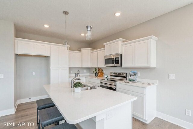 4208 NE 5th St, Ankeny, IA 50021 - kitchen featuring appliances with stainless steel finishes, a sink, light wood finished floors, white cabinetry, and recessed lighting