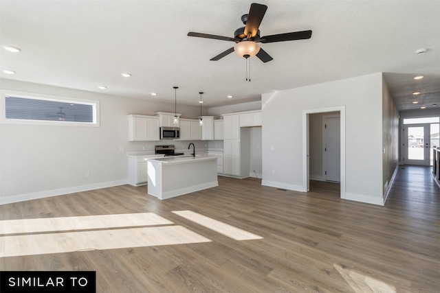 4208 NE 5th St, Ankeny, IA 50021 - kitchen with stainless steel microwave, electric range oven, a sink, a kitchen island with sink, and a ceiling fan