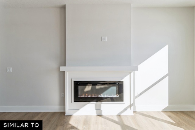 4208 NE 5th St, Ankeny, IA 50021 - detailed view of wood finished floors, baseboards, and a glass covered fireplace