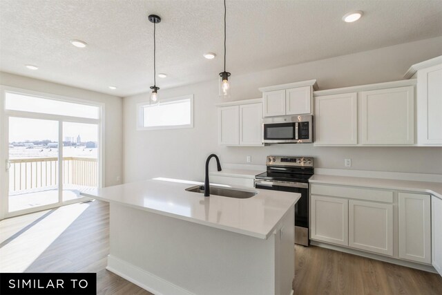 4208 NE 5th St, Ankeny, IA 50021 - kitchen with stainless steel appliances, a sink, white cabinets, pendant lighting, and a textured ceiling