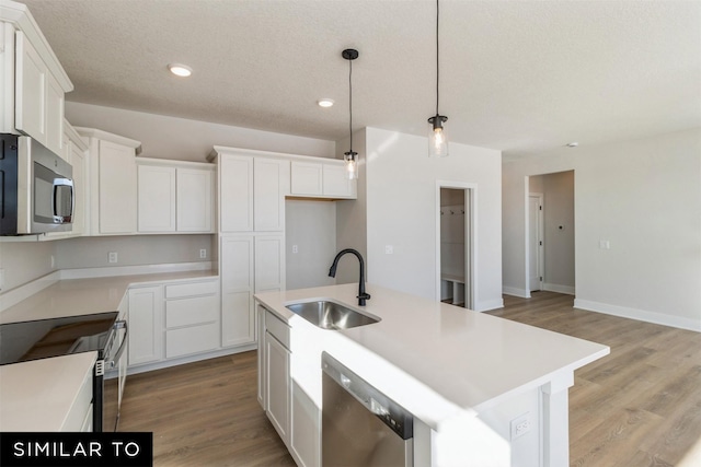 4208 NE 5th St, Ankeny, IA 50021 - kitchen featuring stainless steel appliances, a sink, white cabinets, light wood-style floors, and recessed lighting