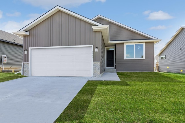 4212 NE 5th St, Ankeny, IA 50021 - view of front of house with a garage, a front lawn, concrete driveway, stone siding, and board and batten siding