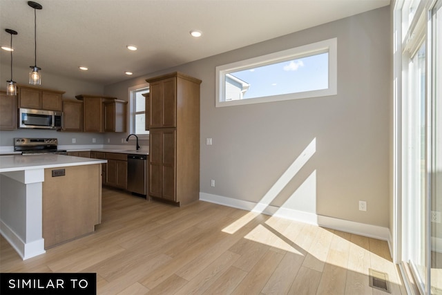 4212 NE 5th St, Ankeny, IA 50021 - kitchen featuring appliances with stainless steel finishes, light wood-style flooring, light countertops, hanging light fixtures, and recessed lighting
