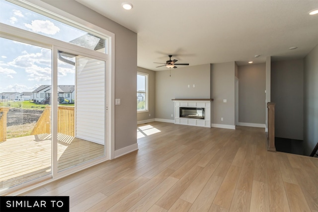 4212 NE 5th St, Ankeny, IA 50021 - unfurnished living room featuring light wood-style flooring, a ceiling fan, baseboards, a fireplace, and recessed lighting