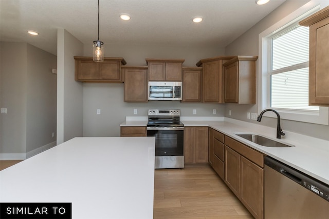 4212 NE 5th St, Ankeny, IA 50021 - kitchen featuring appliances with stainless steel finishes, a sink, light wood finished floors, recessed lighting, and light countertops