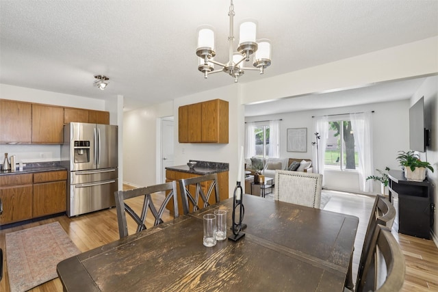 2501 SE 18th Ct, Des Moines, IA 50320 - dining area featuring a chandelier, light wood-type flooring, and a textured ceiling