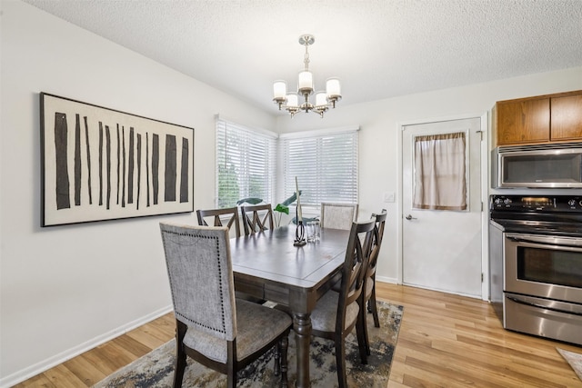 2501 SE 18th Ct, Des Moines, IA 50320 - dining area featuring a chandelier, light wood-type flooring, baseboards, and a textured ceiling