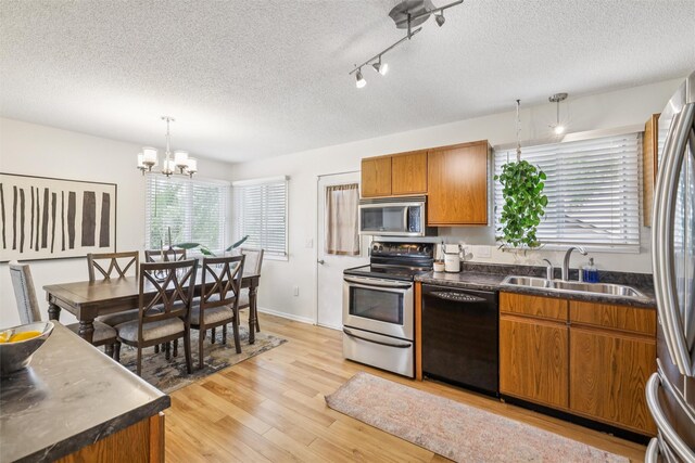 2501 SE 18th Ct, Des Moines, IA 50320 - kitchen featuring appliances with stainless steel finishes, a sink, a textured ceiling, brown cabinets, and dark countertops
