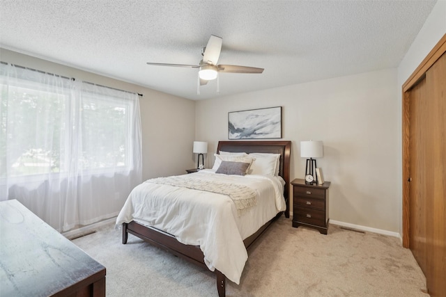 2501 SE 18th Ct, Des Moines, IA 50320 - bedroom featuring light colored carpet, a textured ceiling, ceiling fan, and a closet