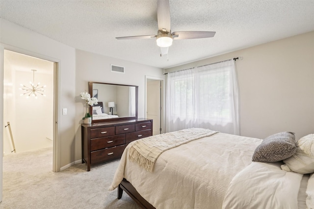 2501 SE 18th Ct, Des Moines, IA 50320 - bedroom featuring light carpet, a chandelier, a textured ceiling, and ceiling fan