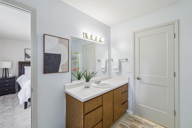 2501 SE 18th Ct, Des Moines, IA 50320 - full bath featuring vanity, connected bathroom, a textured ceiling, and a shower