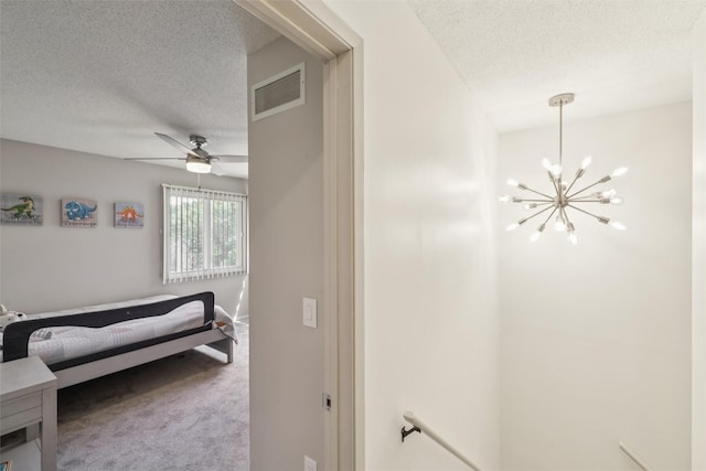 2501 SE 18th Ct, Des Moines, IA 50320 - carpeted bedroom with a textured ceiling, a chandelier, and ceiling fan