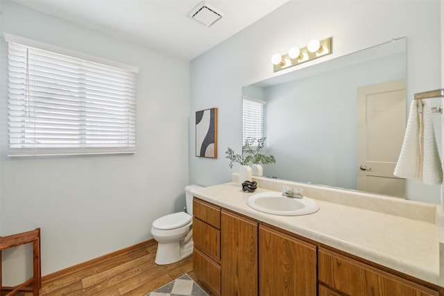 2501 SE 18th Ct, Des Moines, IA 50320 - bathroom with vanity, toilet, plenty of natural light, and wood finished floors