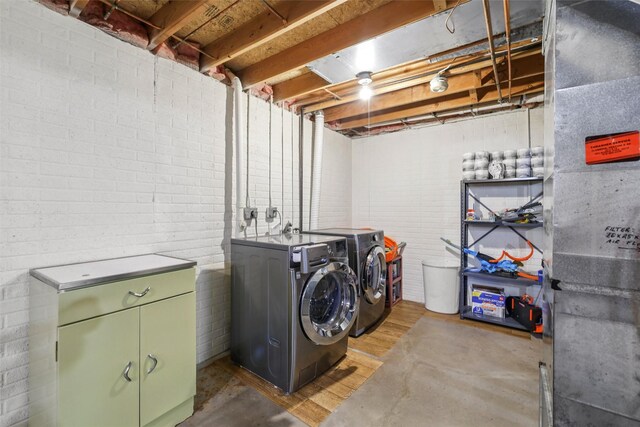 2501 SE 18th Ct, Des Moines, IA 50320 - washroom featuring independent washer and dryer, cabinet space, and wood finished floors