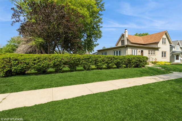 1723 6th St, Perry, IA 50220 - view of property exterior featuring a chimney and a lawn