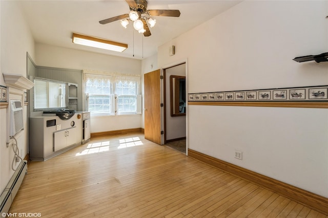 1723 6th St, Perry, IA 50220 - unfurnished living room featuring a baseboard radiator, ceiling fan, light wood-style flooring, and baseboards