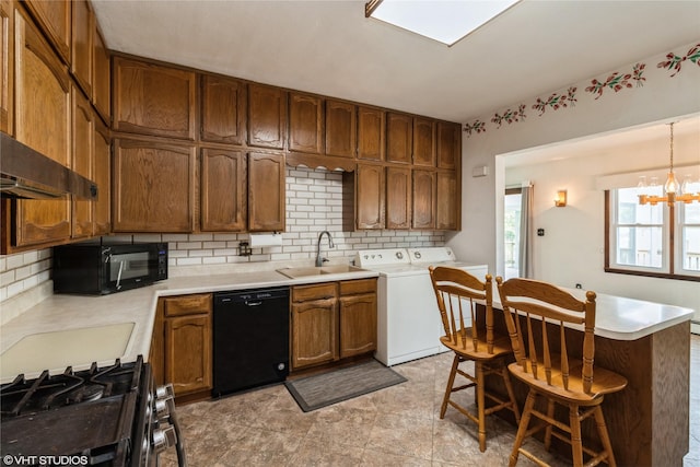 1723 6th St, Perry, IA 50220 - kitchen with black appliances, a sink, washing machine and dryer, tasteful backsplash, and light countertops